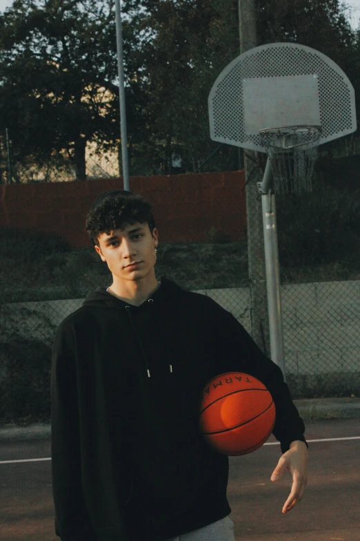 a man holding a basketball in his left hand