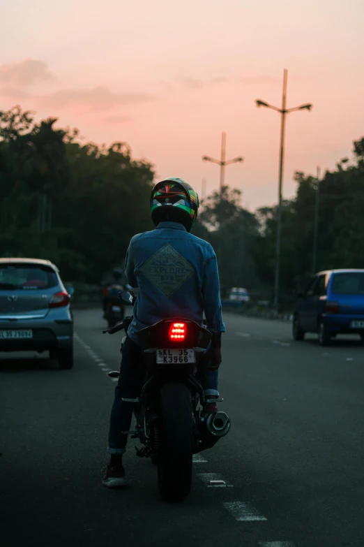 a person on a motor bike with the sun setting in the background