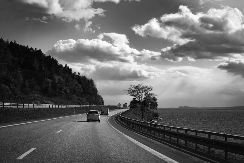 a black and white po of a car passing down a highway