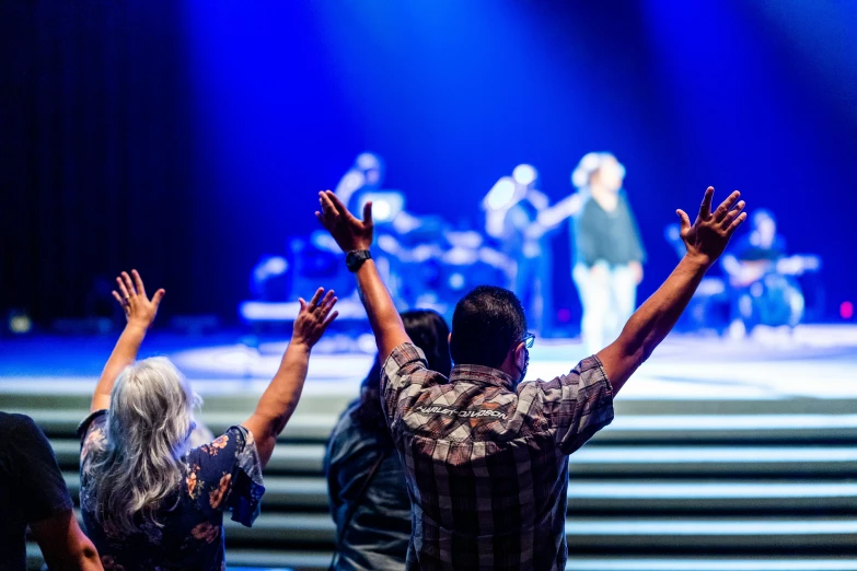 two people raising their hands at a concert