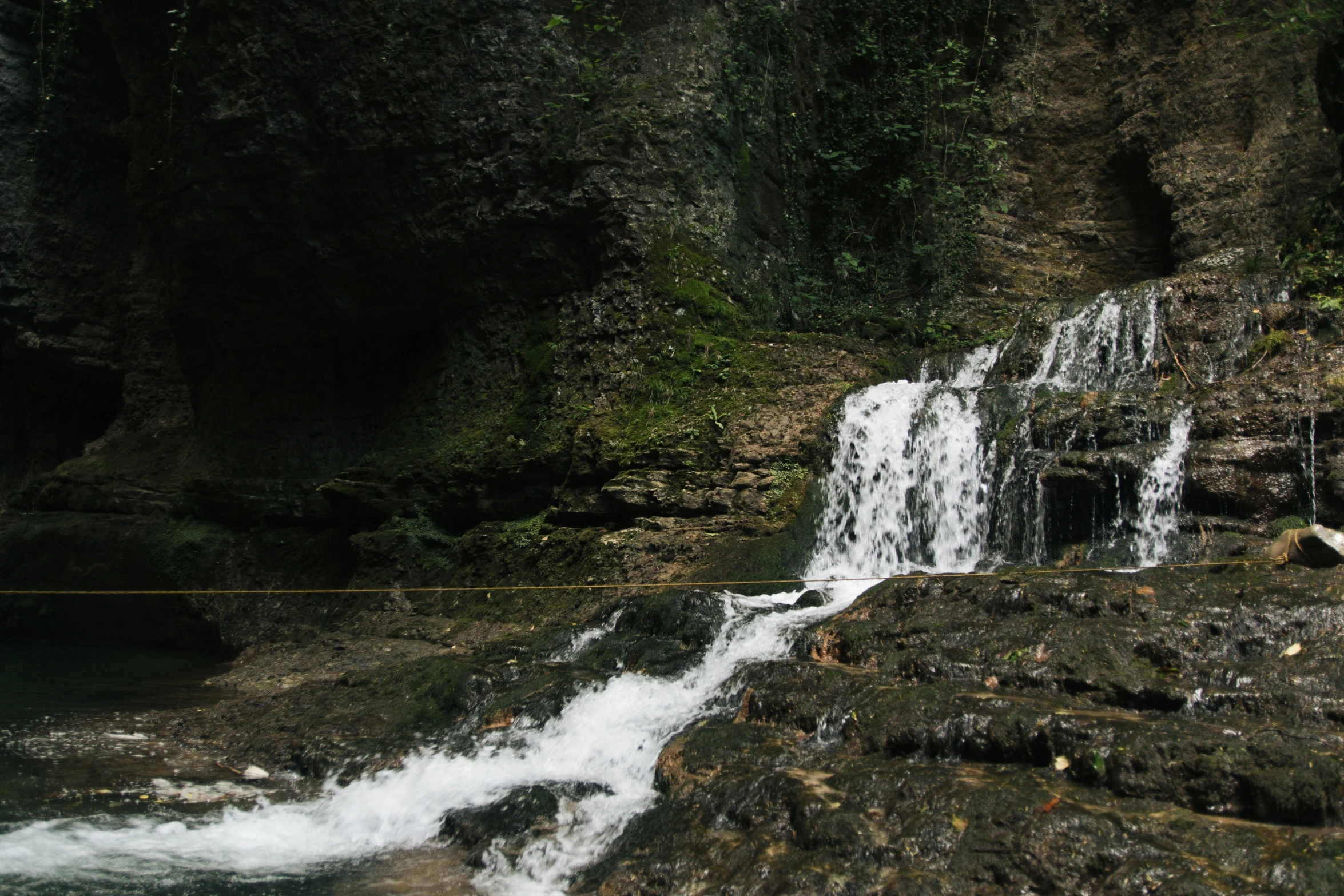 a man standing next to a waterfall by the river