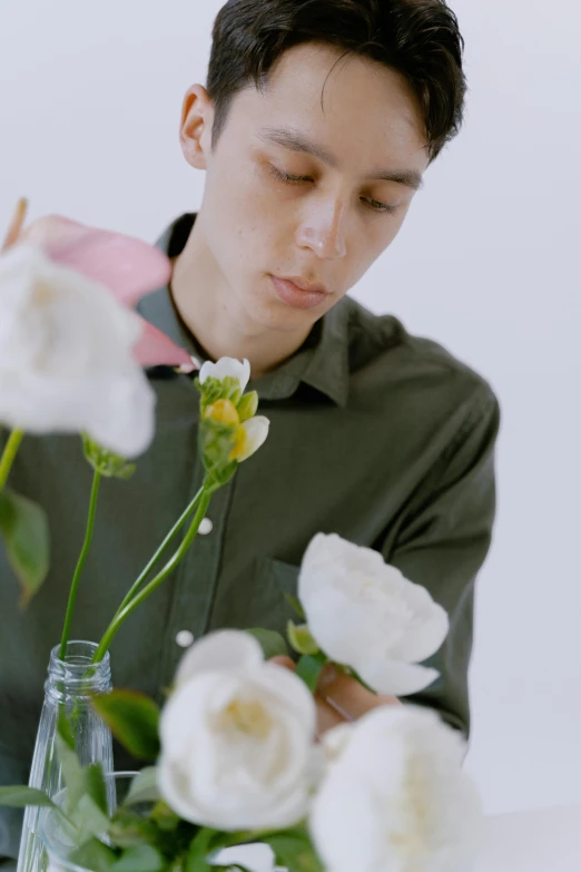 man putting flowers in the vase on the table