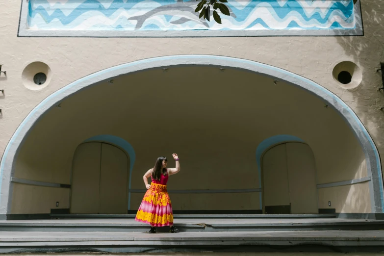 a girl in a colorful dress taking a picture