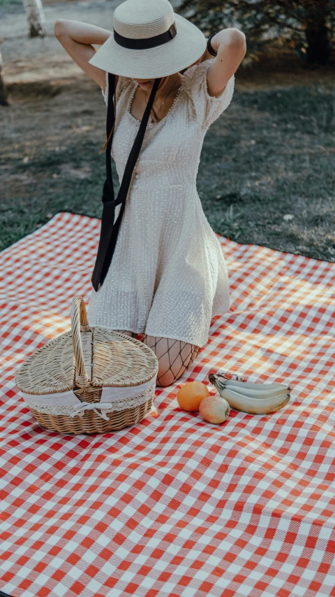 a woman sitting at a table with her hat and some food