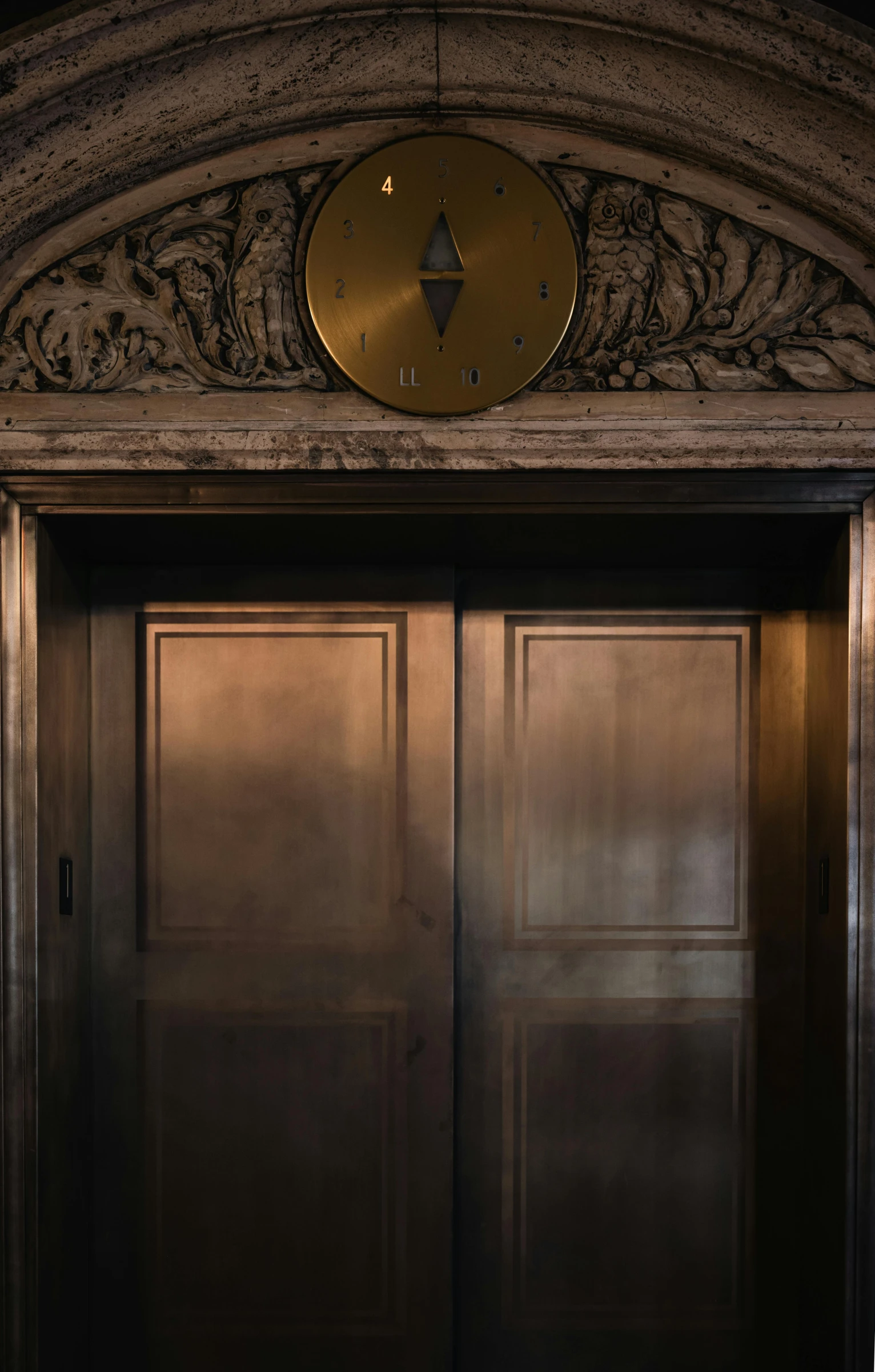 the entrance to a building with two doors and a large clock