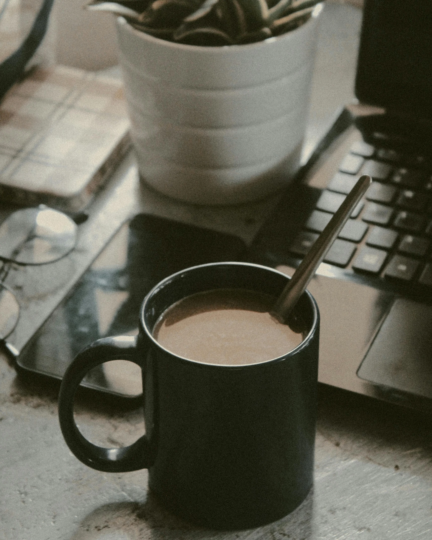 a black cup and a coffee mug are on the desk