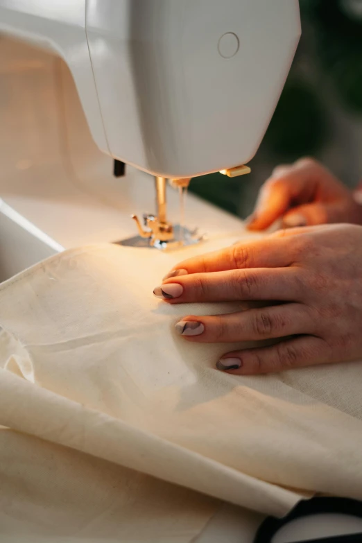 a person is using a sewing machine on cloth