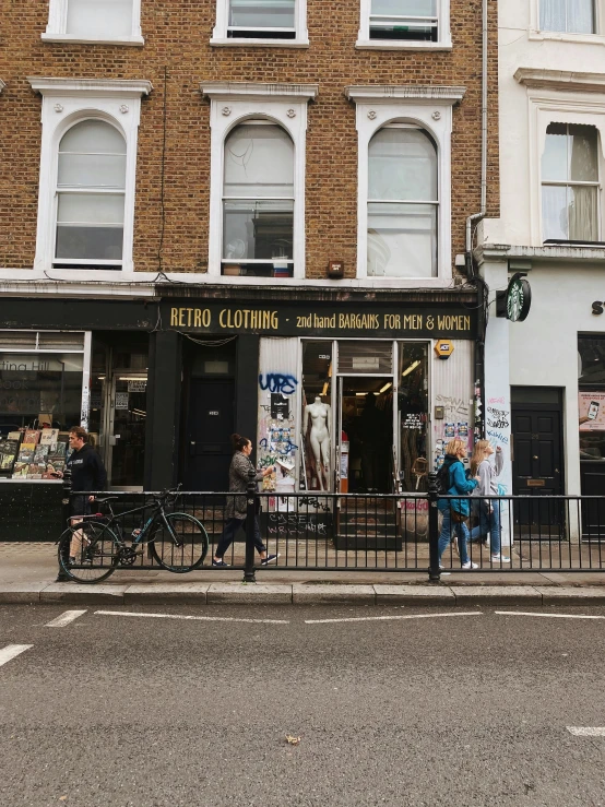 two people sitting on the curb in front of an outdoor cafe