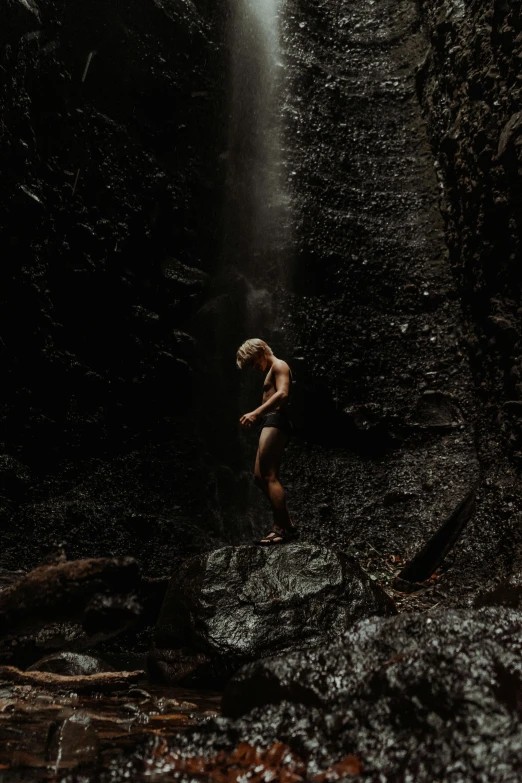 a man stands by the edge of a waterfall