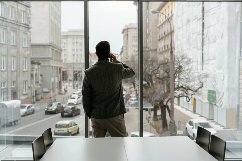 a person stands in a room that has some large windows