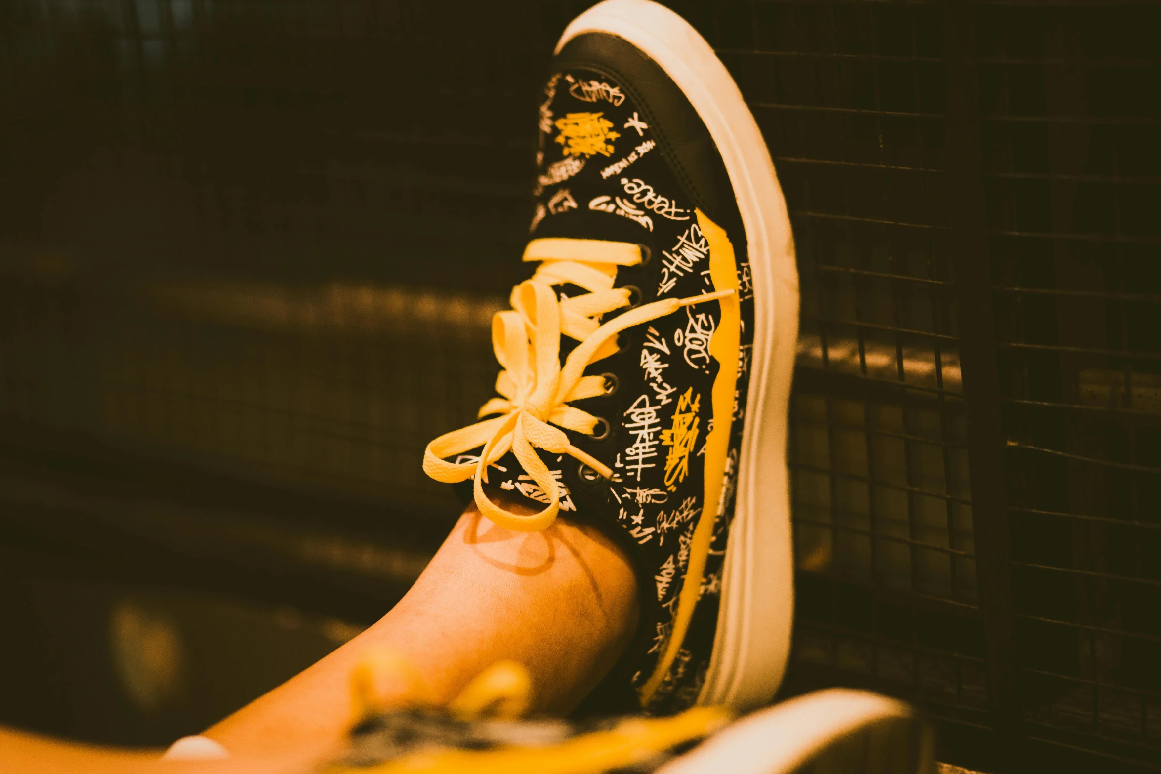 the bottom view of a person's shoe as they stand near some metal bars