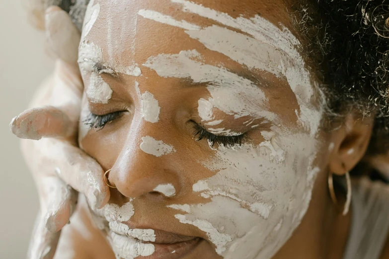 woman's face covered in a lotioned facial mask