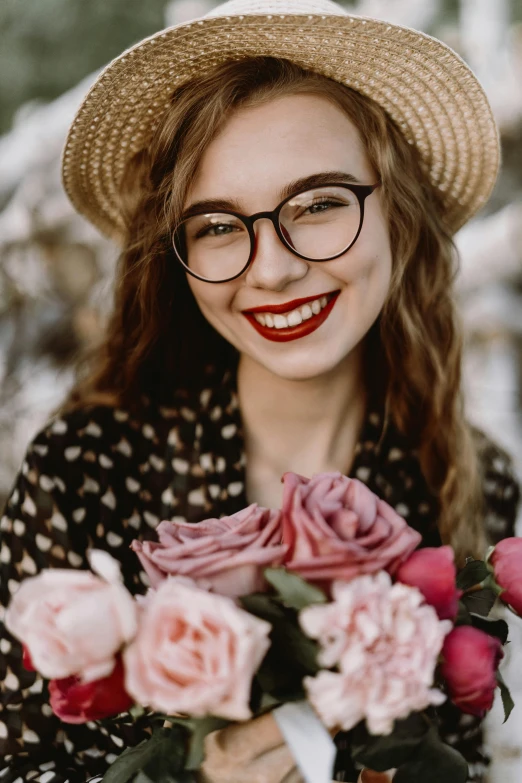 the woman smiles and holds a bunch of flowers