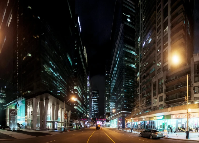 the view of a city street at night with lights shining down