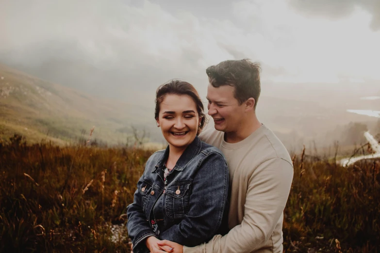 the couple is smiling and emcing while standing near a road