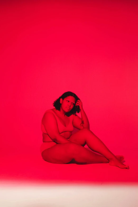 this is a woman posing in lingerie against a red background