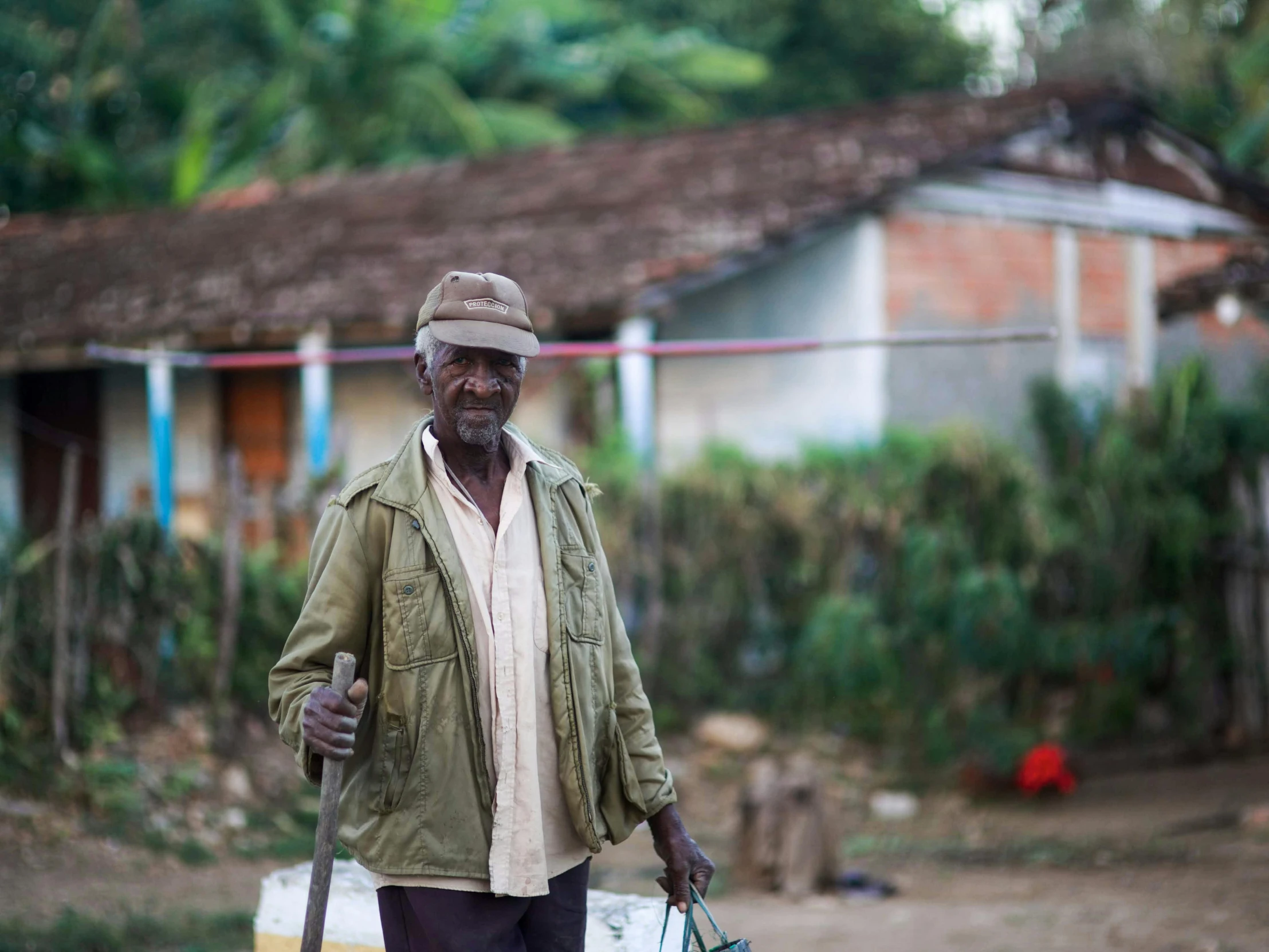 man holding a handbag while walking in a village