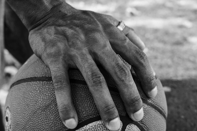 hand of a woman holding a basketball near grass