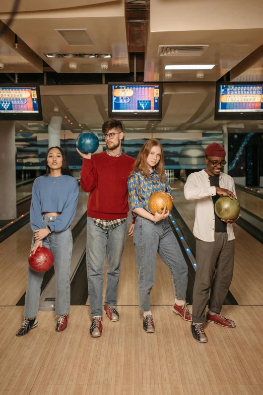 a group of people standing in line with bowling balls