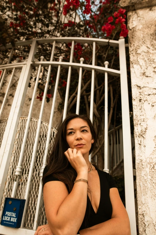 a women who is leaning against a gate