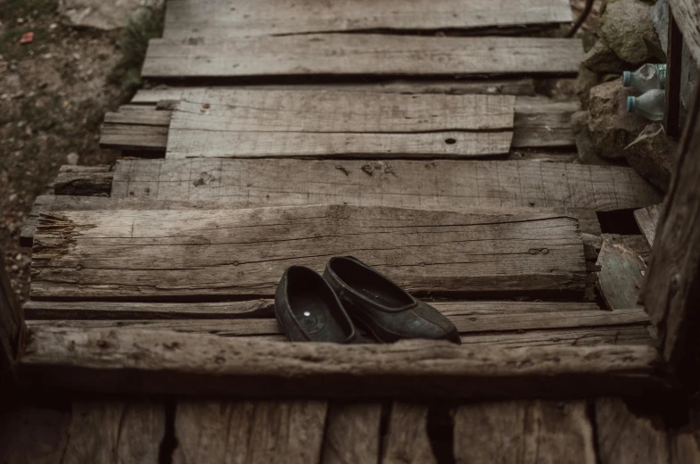 a pair of black shoes sitting on top of wooden steps