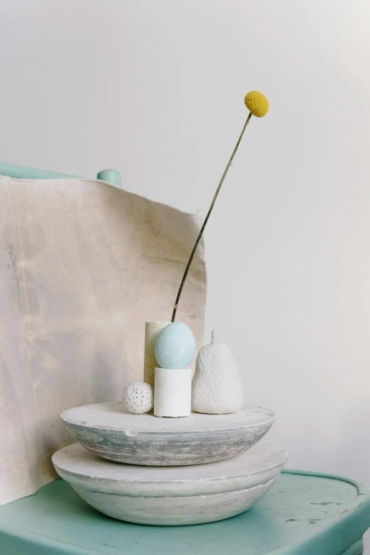 an arrangement of three vases and a flower on a green table