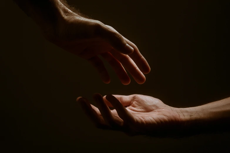 the fingers of two people reaching for each other