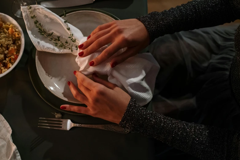 a person with red nails is sitting at a table