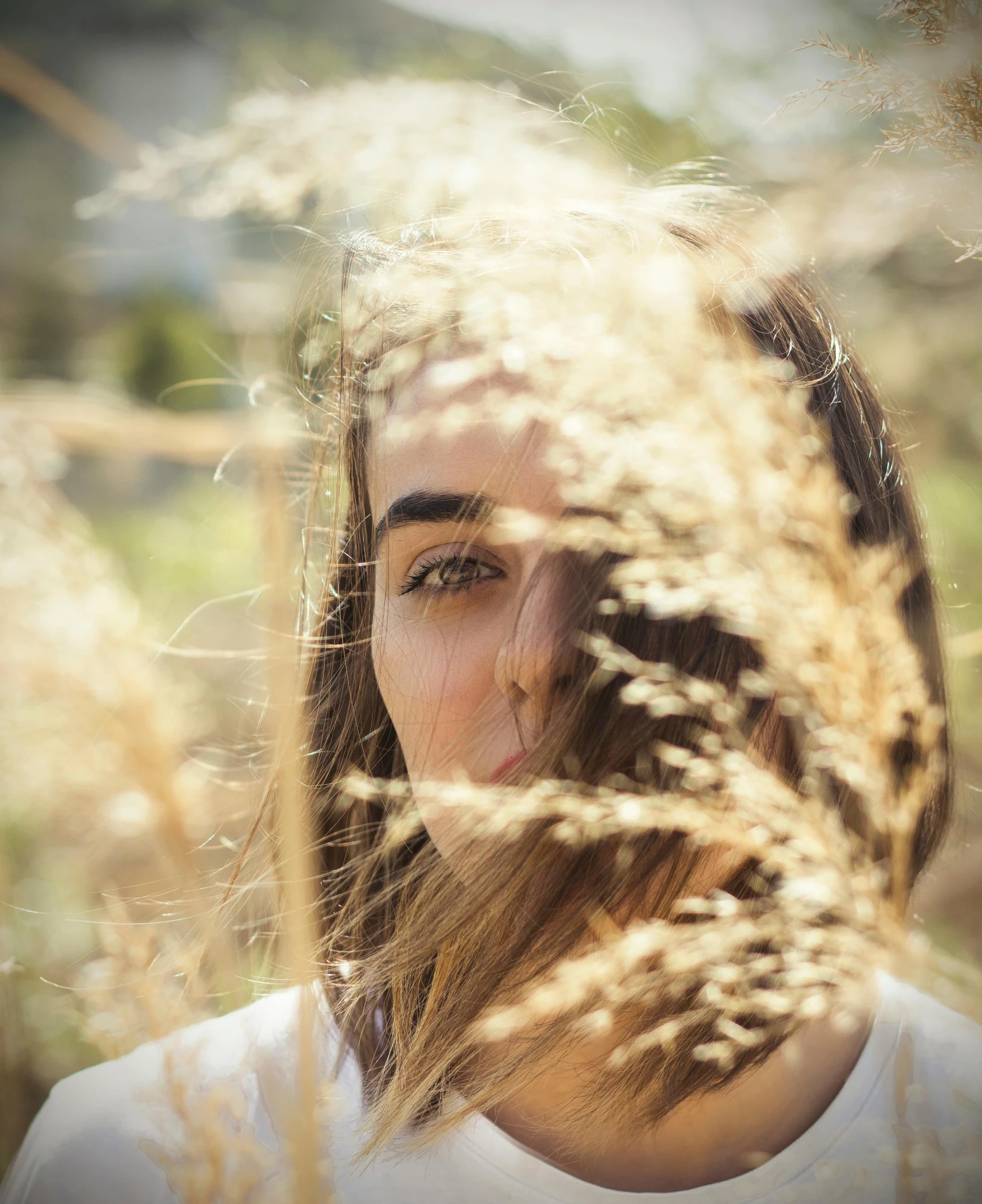 the girl is in front of some tall grass