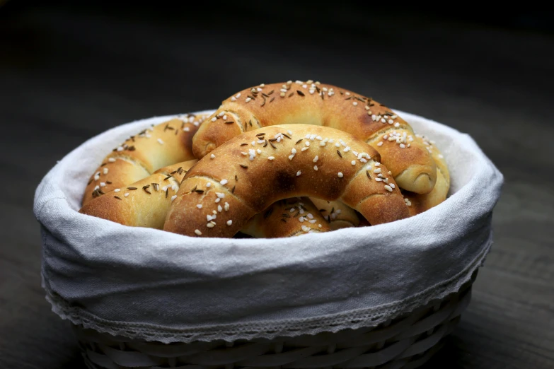 a basket full of sesame bagels on a table