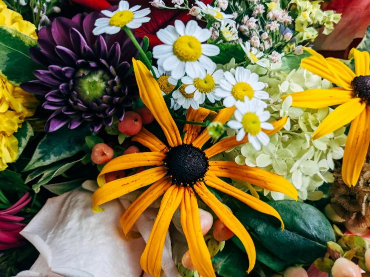 this bouquet has daisies, tulips, and other flower bouquets