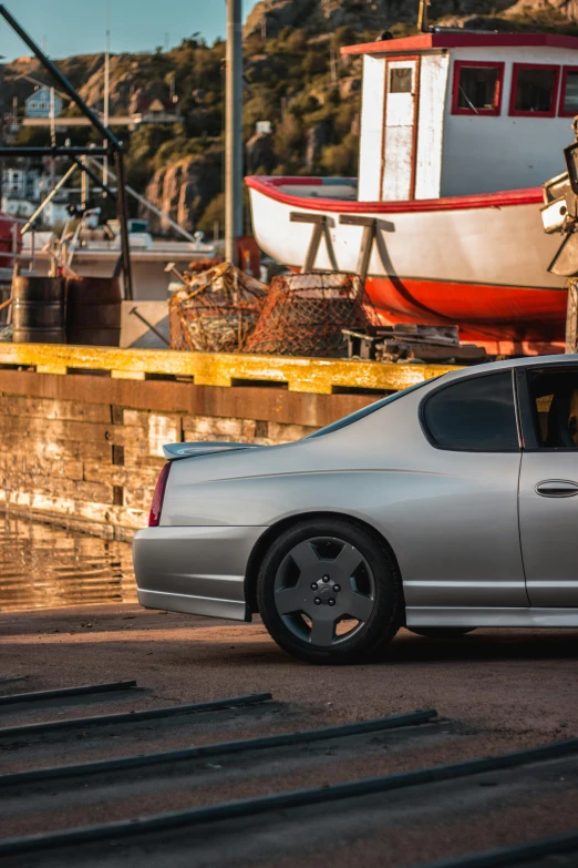 a silver car parked next to a pile of trash