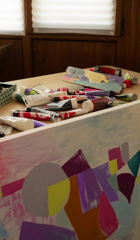 a table with many crayons and papers on top of it