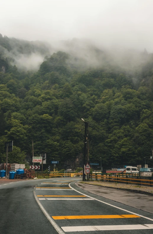 some cars and trucks traveling on a road with some hills in the background