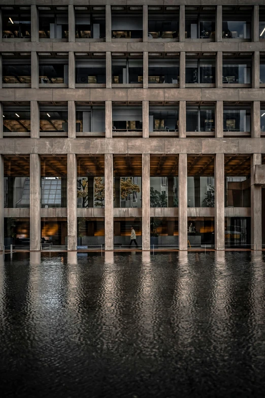 a building has three levels, and its reflection is on the water