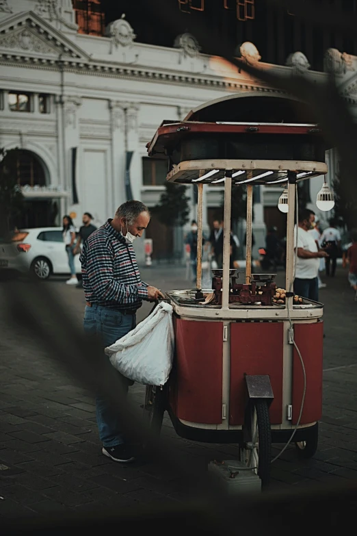 a man hing a cart with an umbrella over it