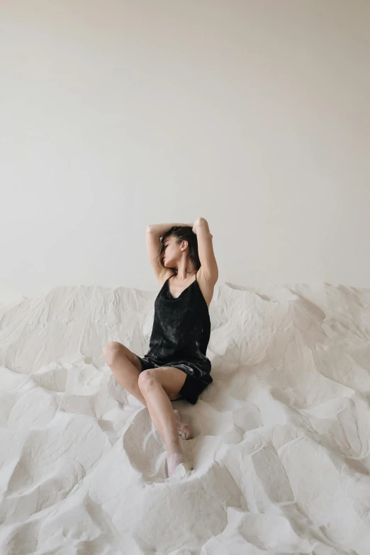 a woman sitting in a bed posing for a po