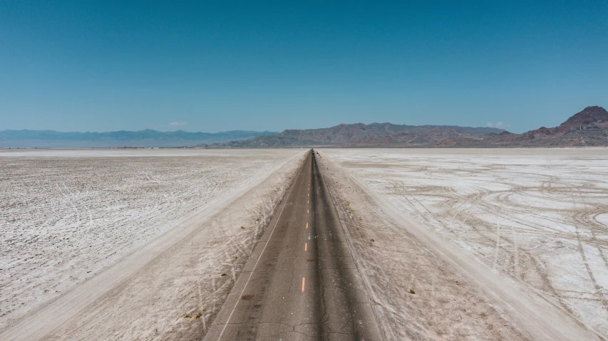 an empty dirt road near mountains in the desert