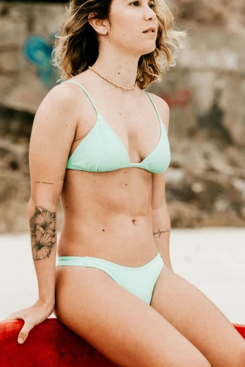a woman wearing a bikini on top of a surfboard