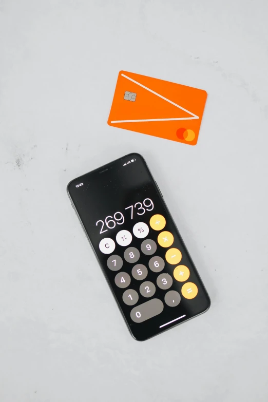 a small remote control sitting next to a bright orange card