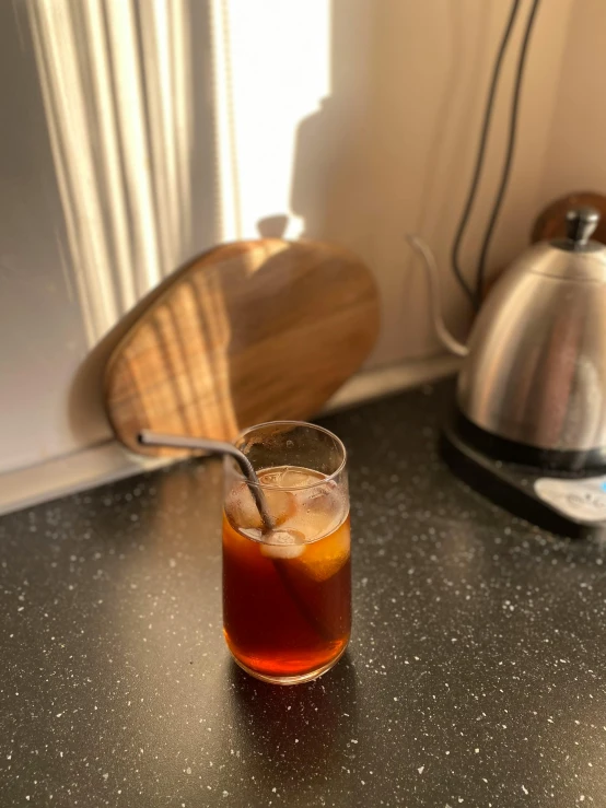 a glass is next to an electric tea pot and a coffee pot