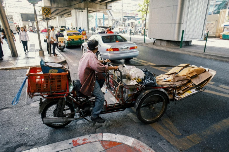 there is a man riding a bike with an attached cart