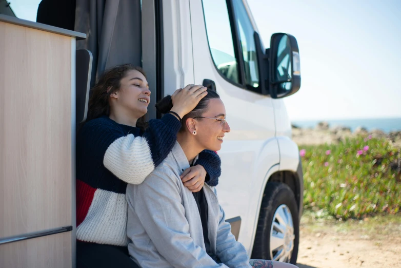 two women are getting off of a white van