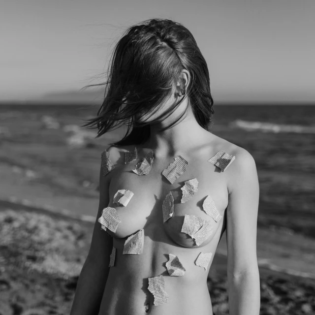 woman with multiple patches on her body standing next to the ocean