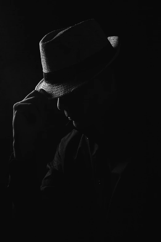 black and white po of man in hat with back light