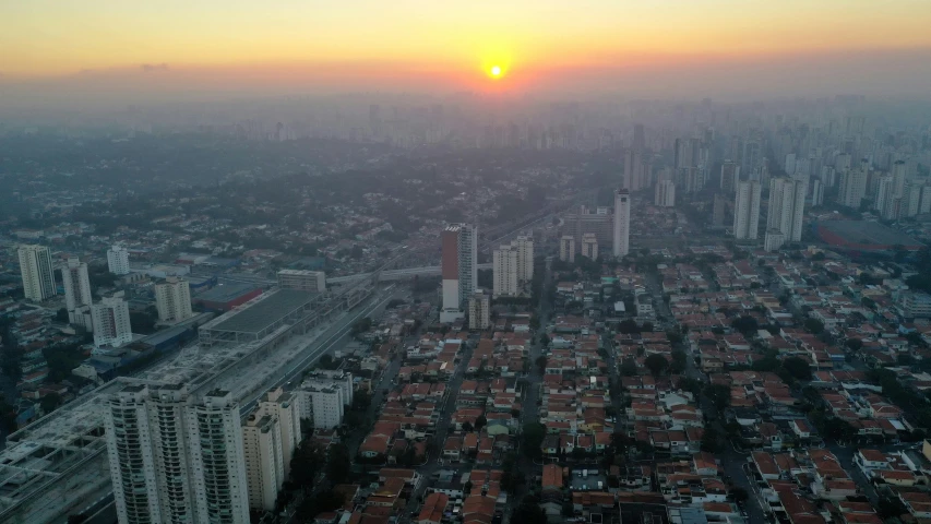 an orange sunset in a city with high rise buildings