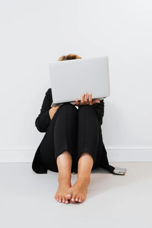 woman sitting on the floor using a laptop