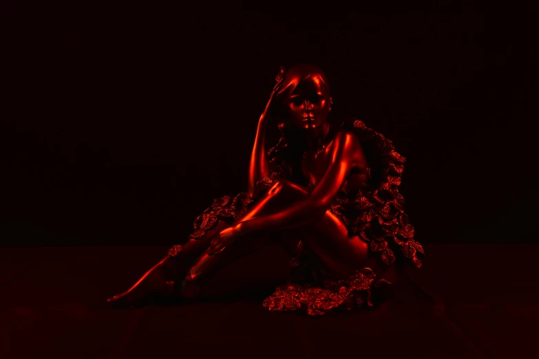 a person with a dress sitting on the ground in the dark