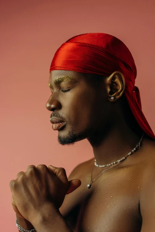 a close up of a shirtless man with a necklace and celet