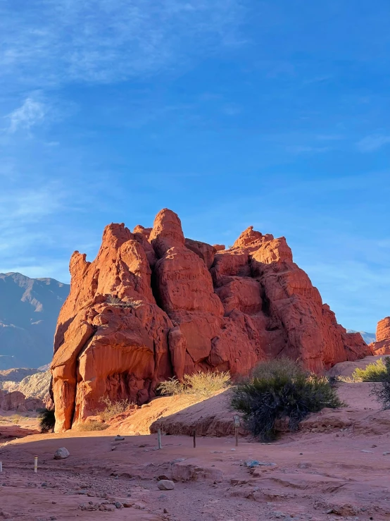 red rocks with hills in the background with a blue sky